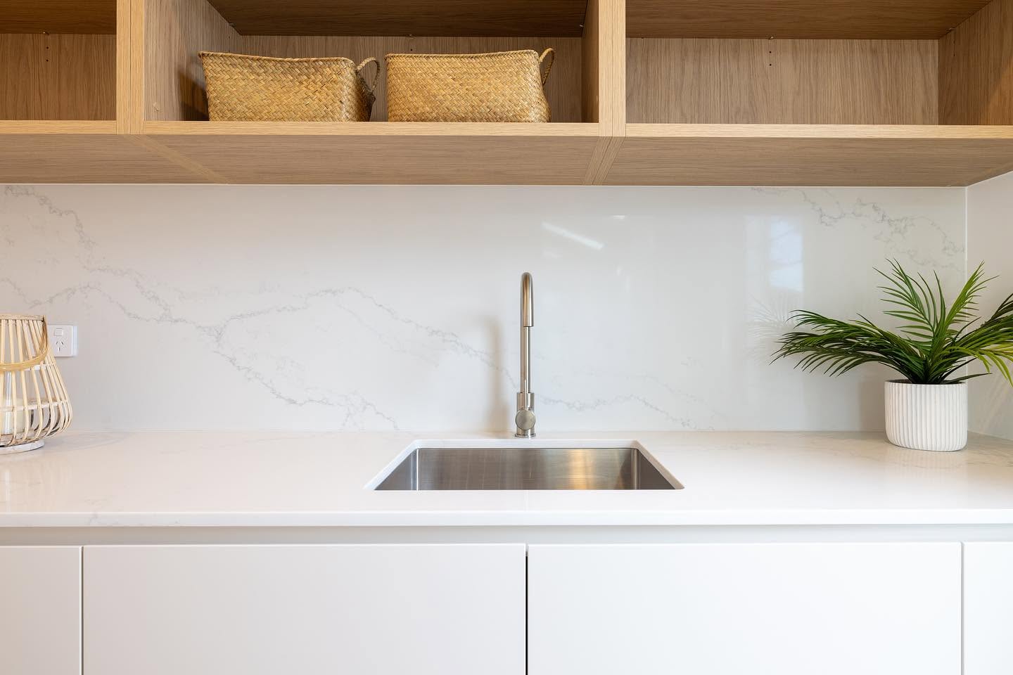 Laundry with stone benchtop, undermount sink and open oak shelving