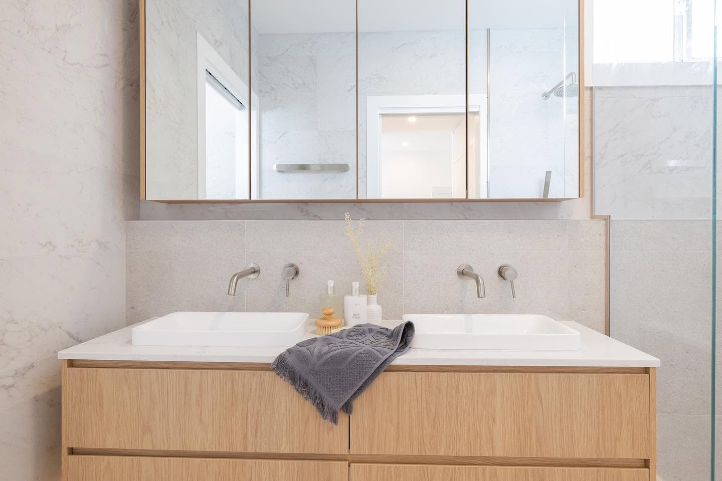 Double vanity with mirrored shaving cabinet and marble-look tiling