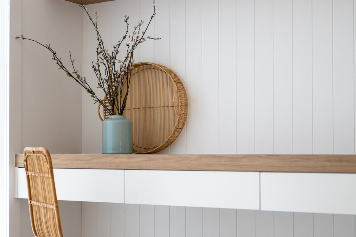 Built-in study nook with oak desktop, white drawers and vertical panelled wall