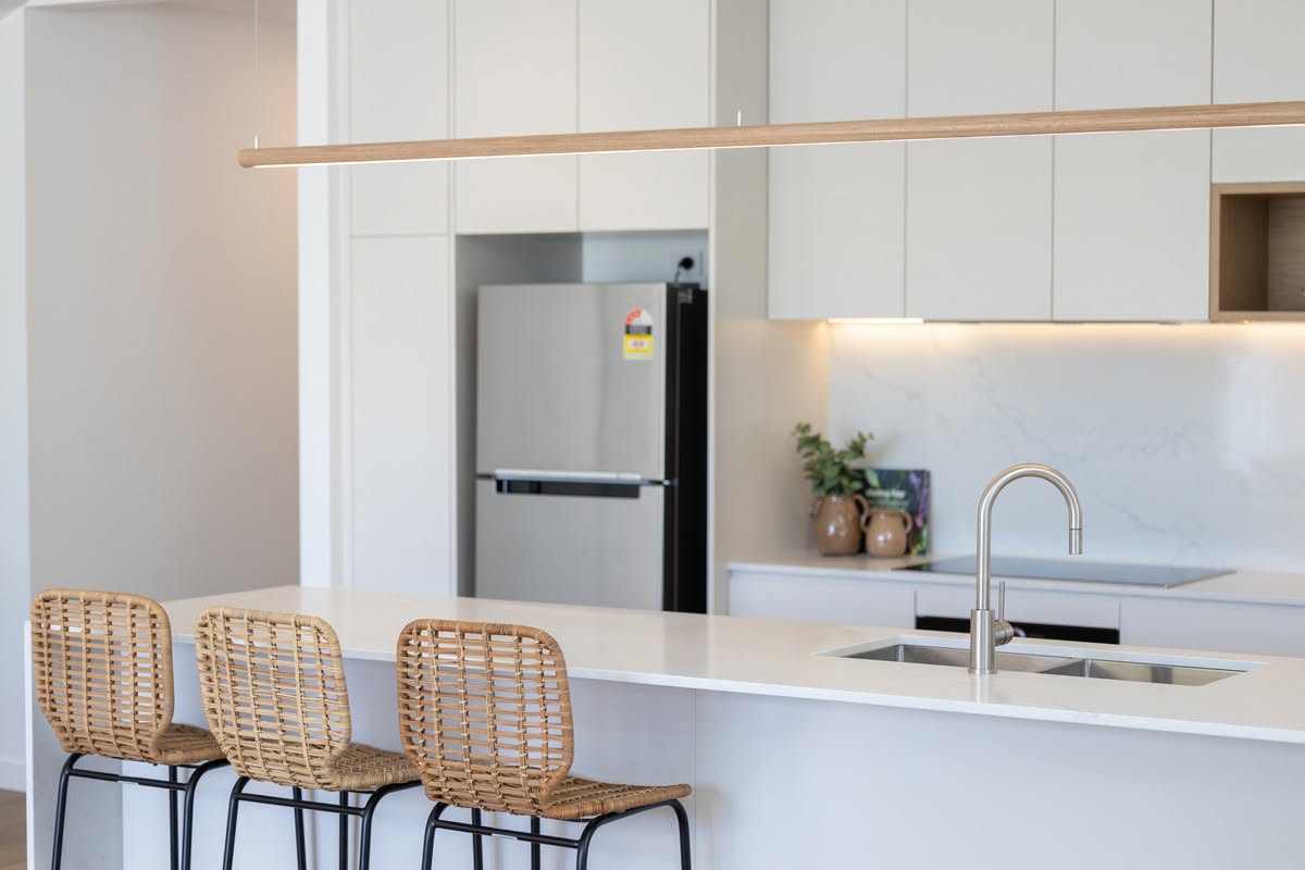 Kitchen island with double sink, gooseneck mixer and linear timber pendant