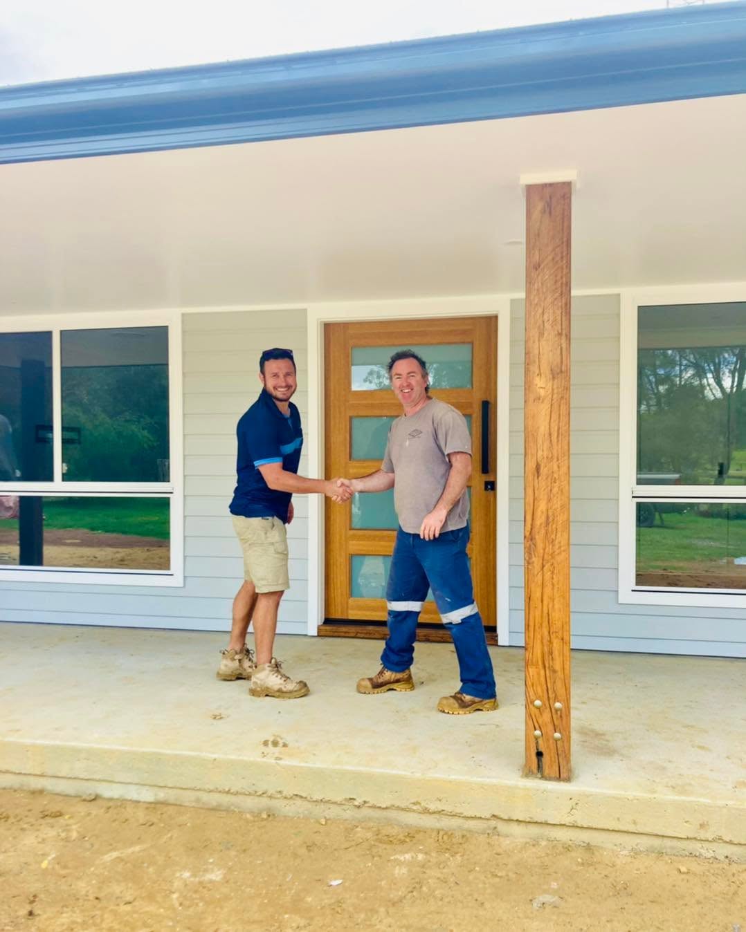 Blue Horizon Projects builder shaking hands with a client in front of a completed Central Coast home