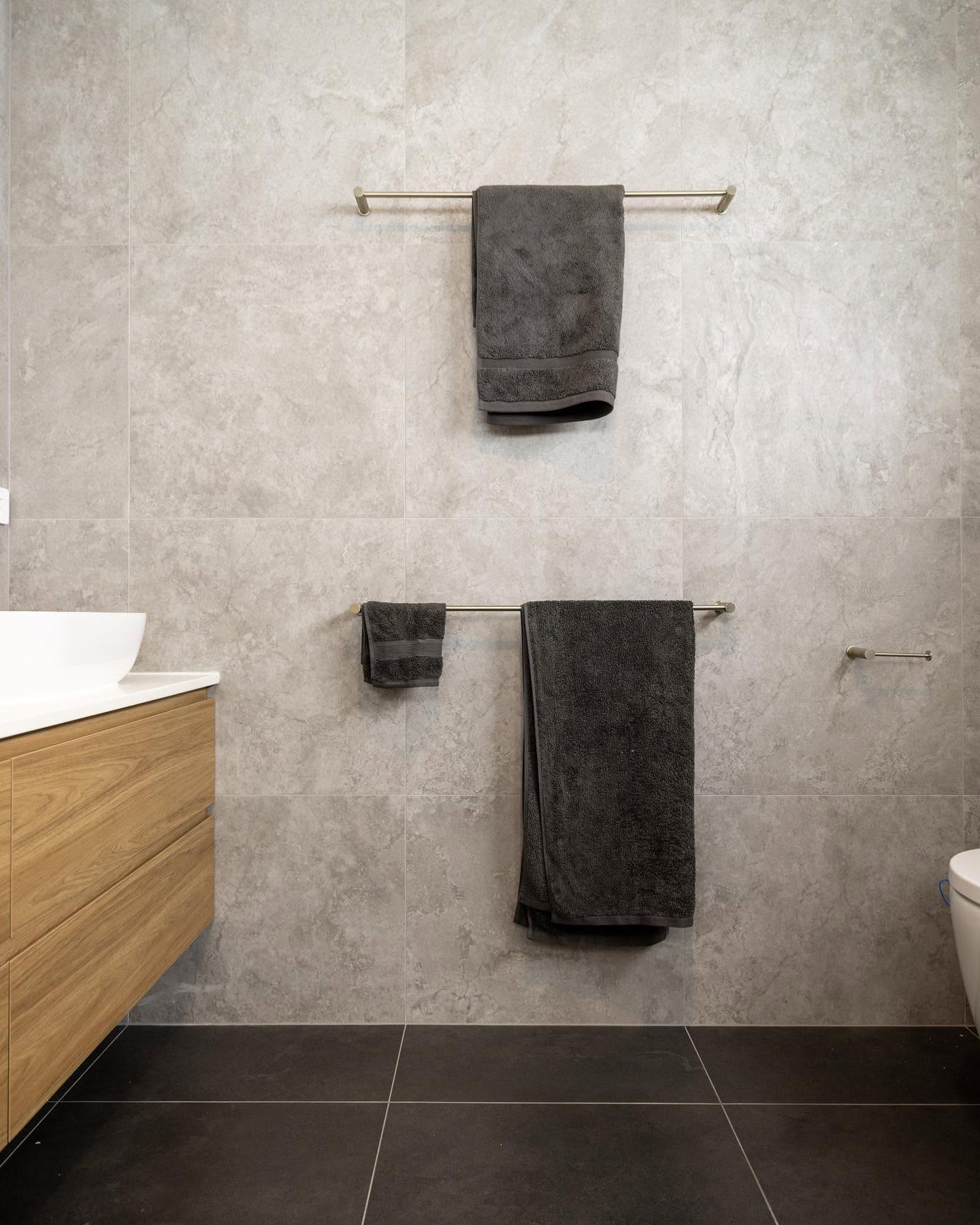 Bathroom with large format stone look tiles, timber vanity and brushed nickel rails
