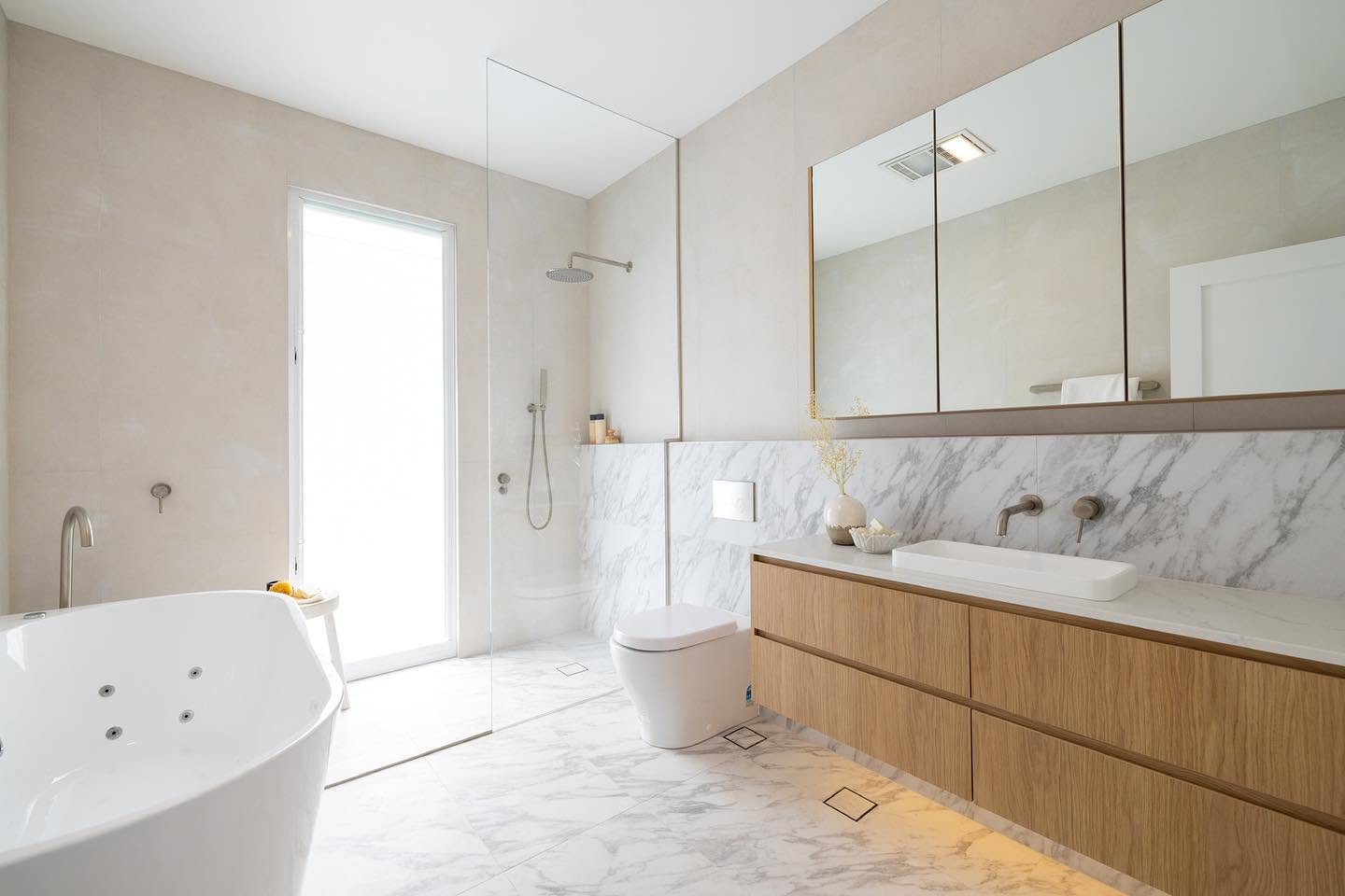 Main bathroom with freestanding spa bath, timber vanity and marble splashback