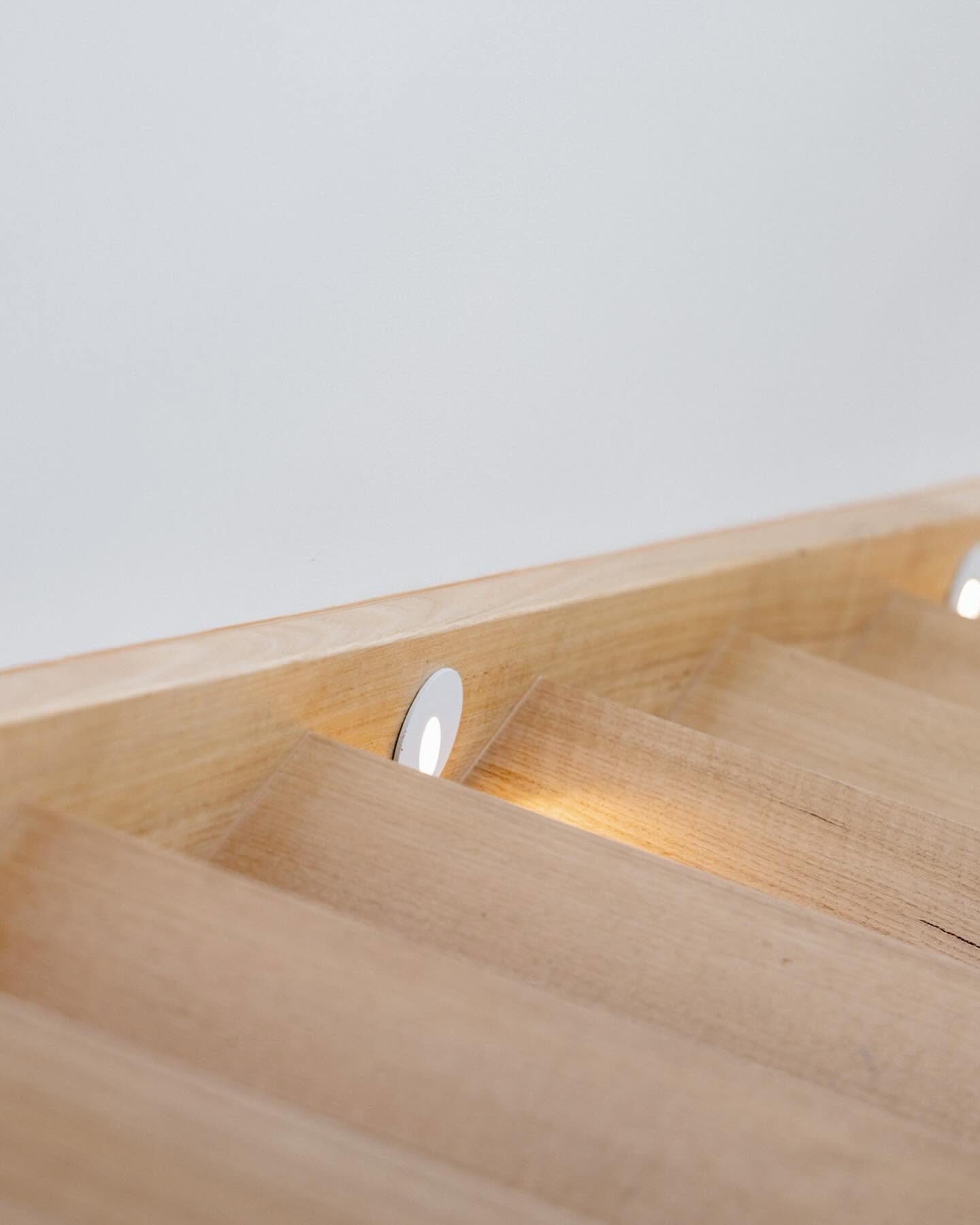 Detail of a solid oak stair tread with a recessed warm step light