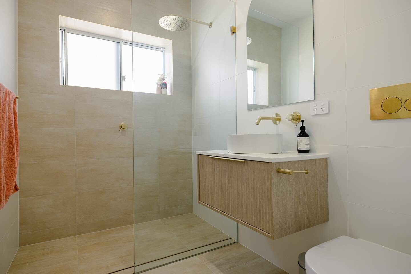 Ensuite with walk-in shower, travertine-look tiling and a floating timber vanity