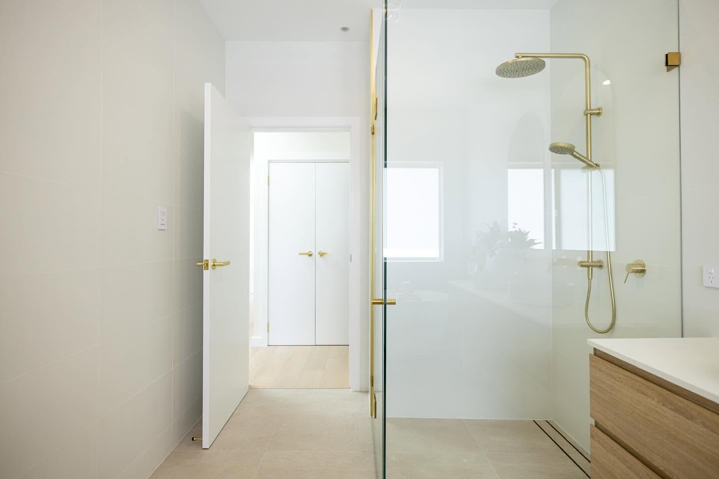 Ensuite with frameless glass shower, brass fixtures and a floating oak vanity