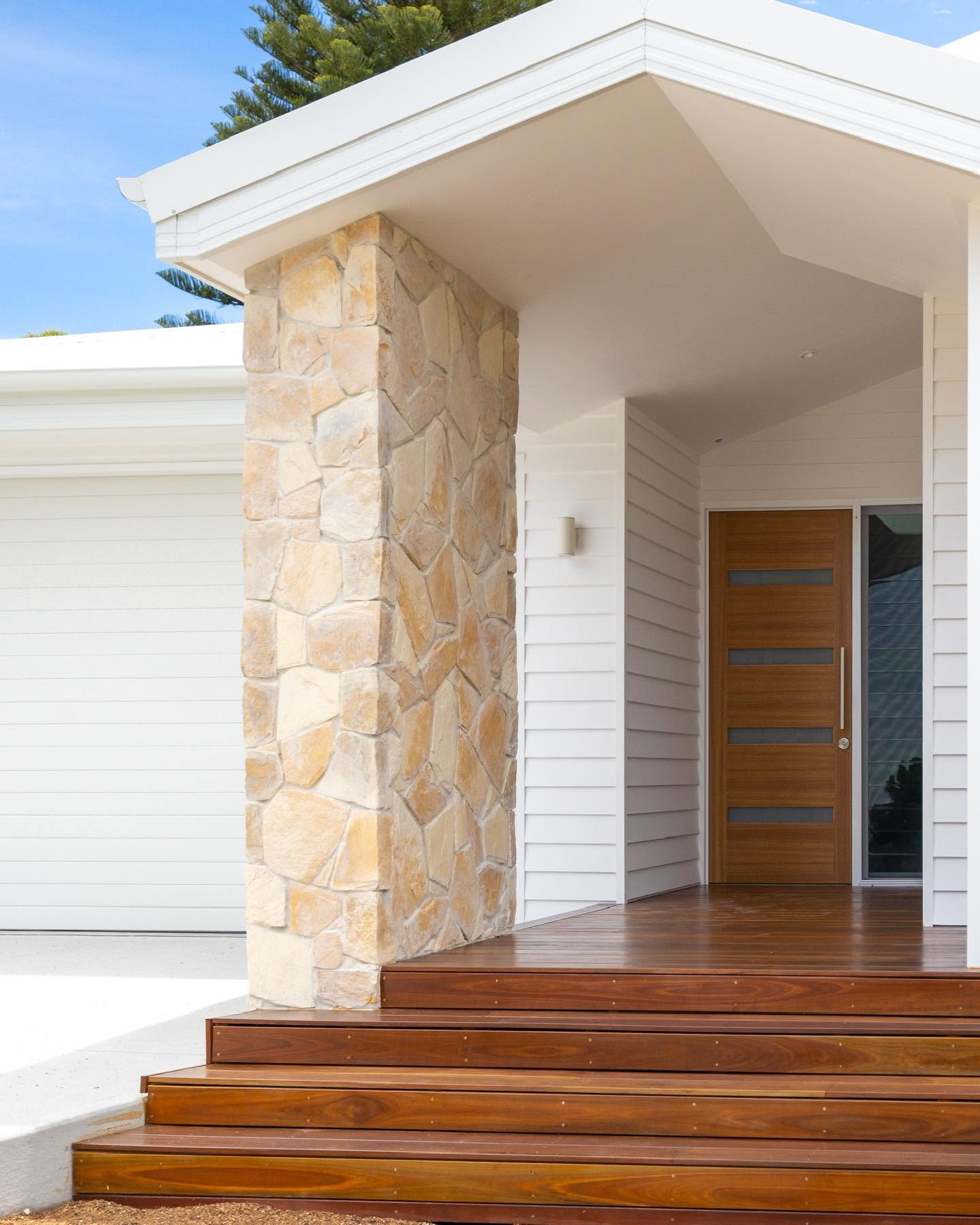 Front entry with sandstone pier, hardwood deck steps and a timber pivot door