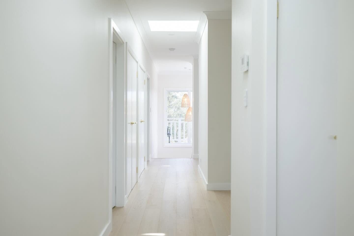 Bright hallway with skylight leading to a balcony in a second storey addition